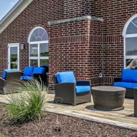 a brick building with blue chairs outside