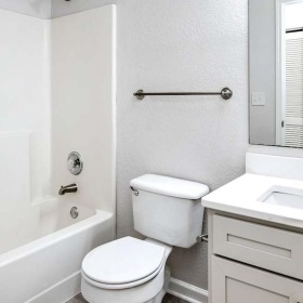 a bathroom with a mirror toilet tub and sink